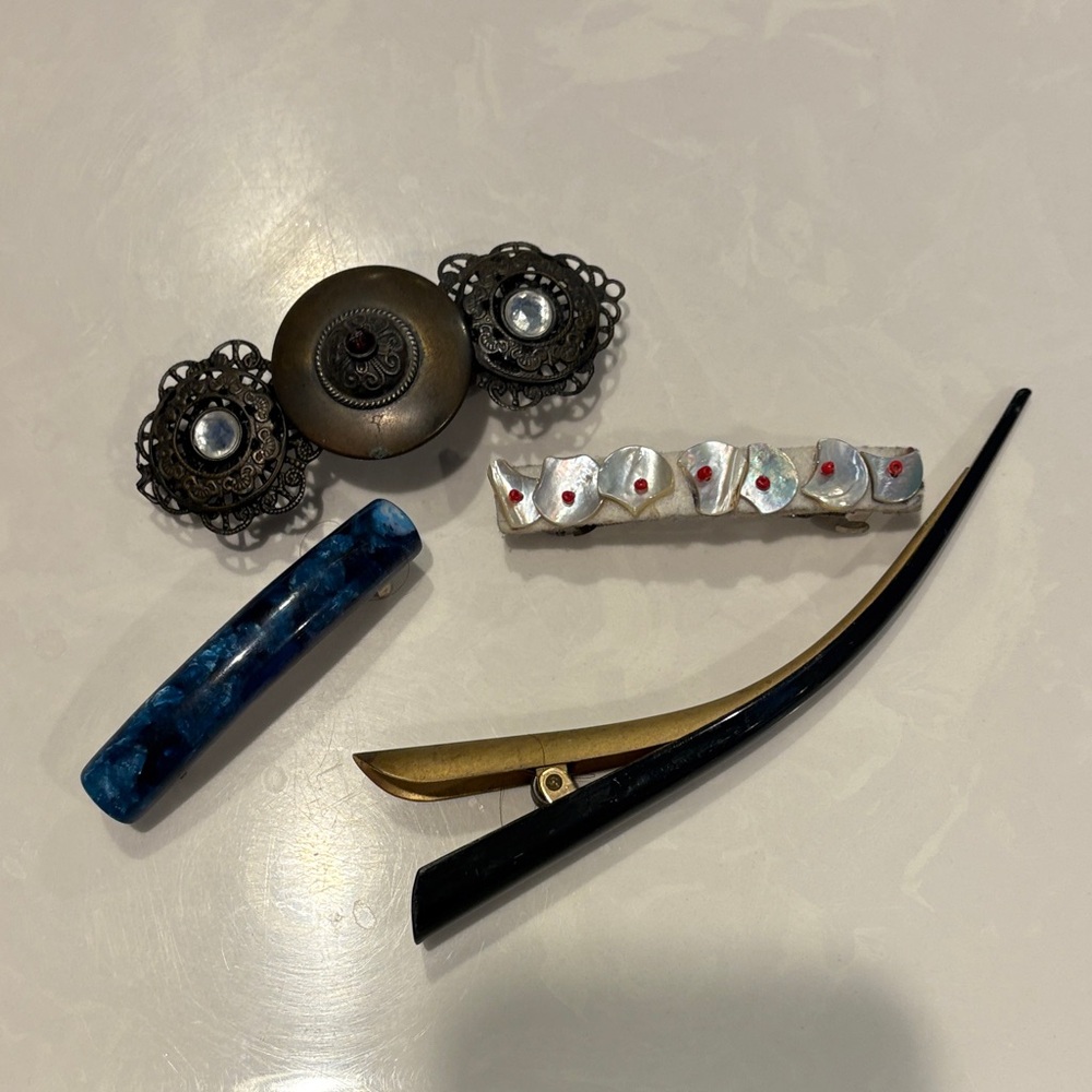 Four vintage hair clips sold as group